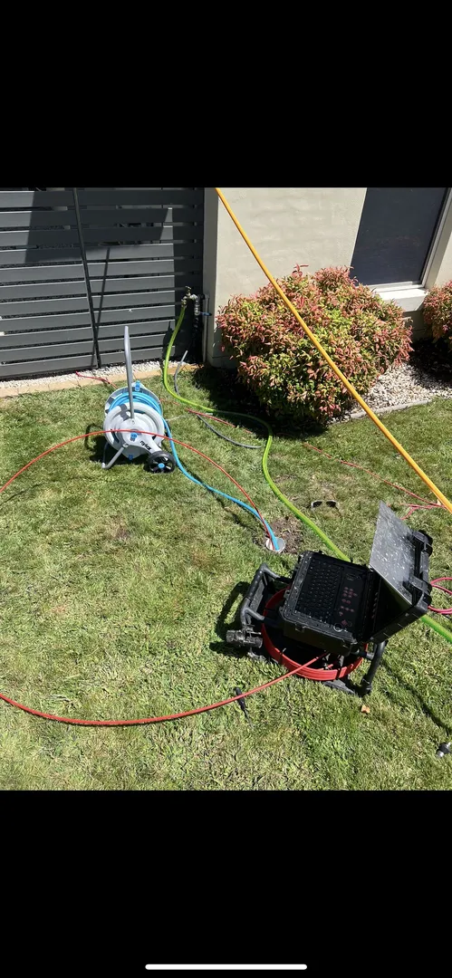 Outdoor plumbing setup with hoses and control equipment.